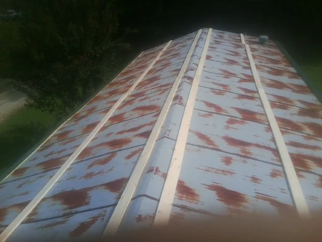 Rusted metal roof panels with new wood purlins before replacement — Storm Damage Roof Repair in Howard City by Roofing Brothers